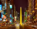 Vista nocturna de la Avenida Corrientes con el Obelisco iluminado al fondo.