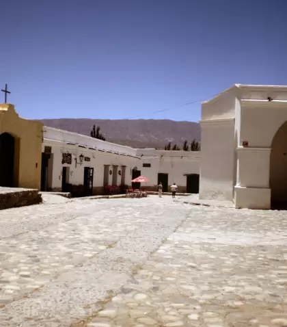 Casas coloniales y la iglesia de Cachi sobresaliendo frente al Nevado de Cachi en un cielo azul profundo.